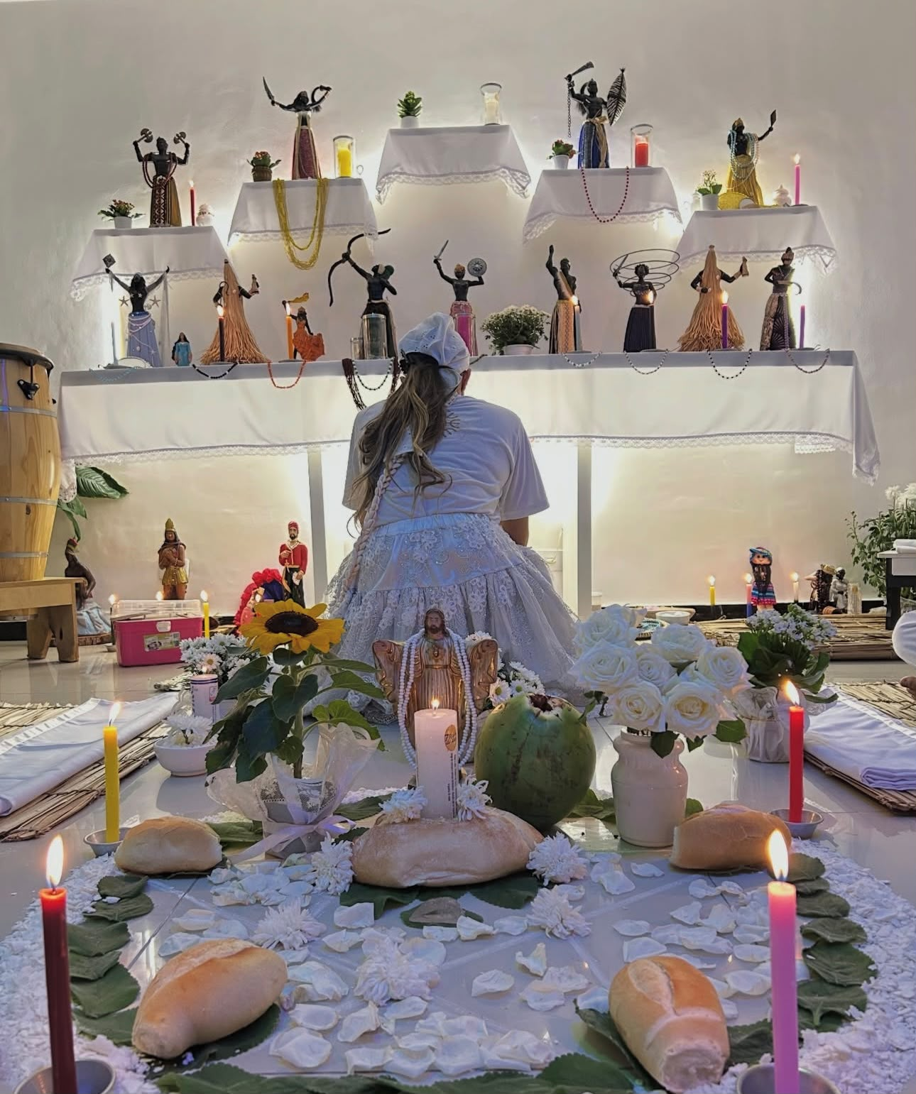 Mesa de leitura com cartas, velas rosas, cristais e pétalas